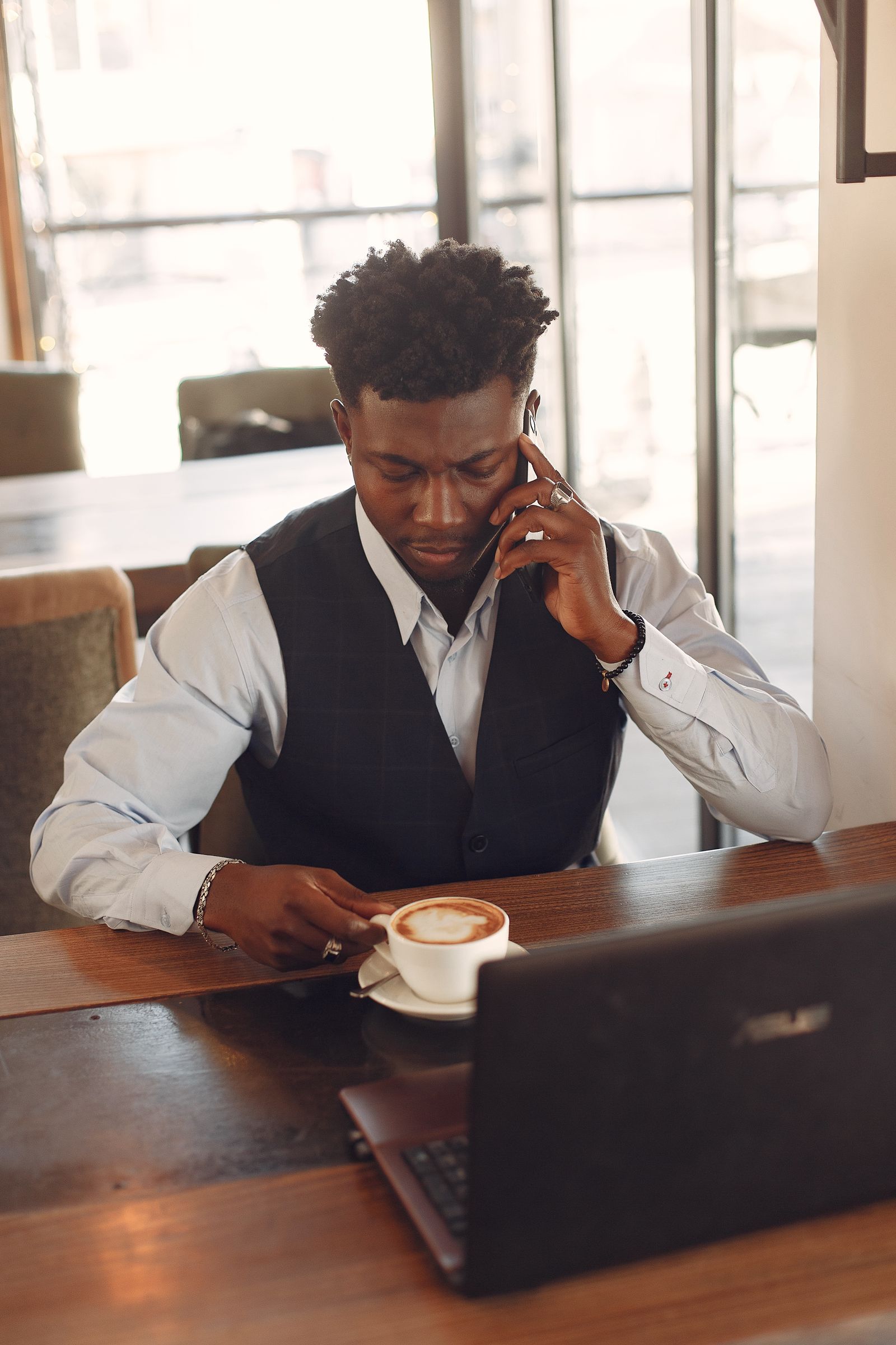 A businessman connecting by phone while working in a cafe