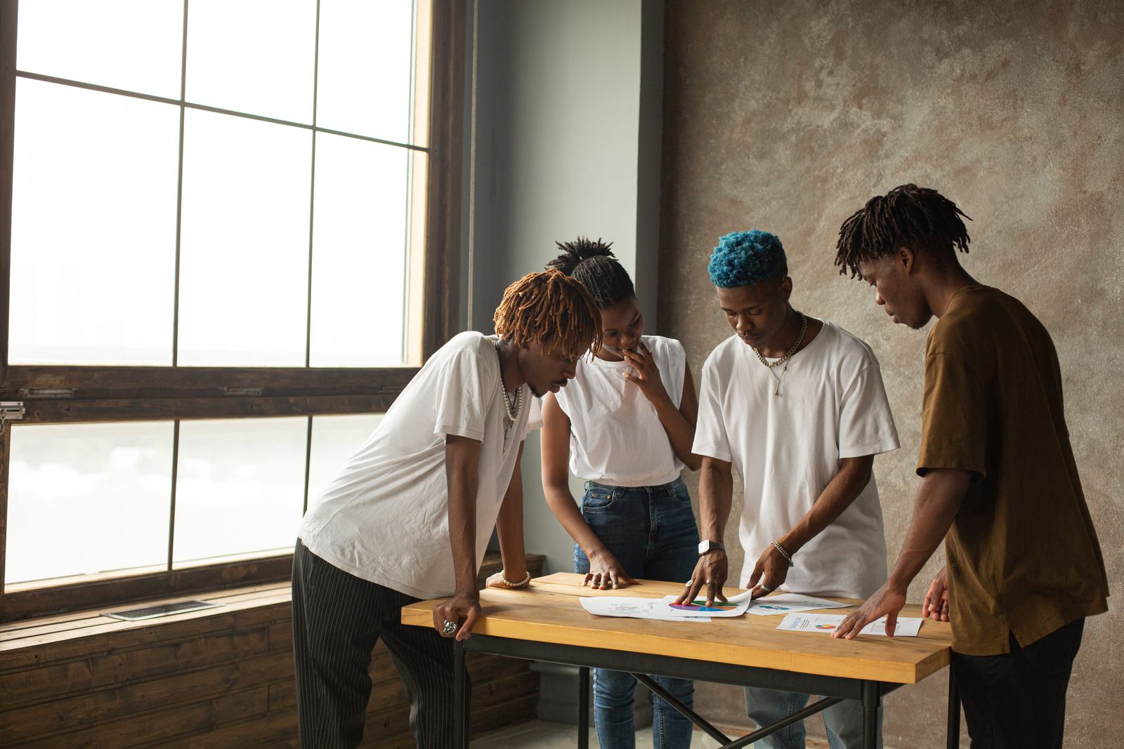 Four entrepreneurs reviewing plans together around a table